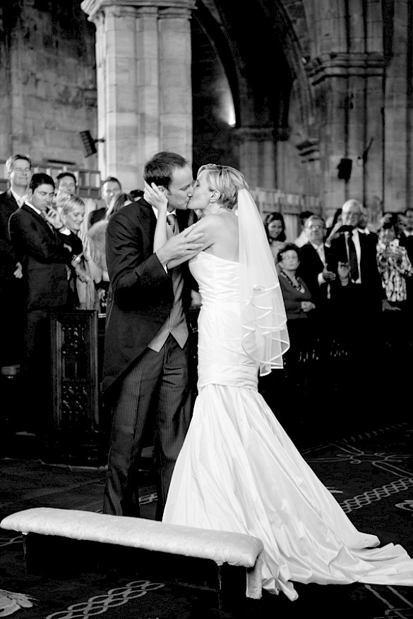 Bride and groom kissing at wedding ceremony at St. Michaels' Parish in Linlithgow