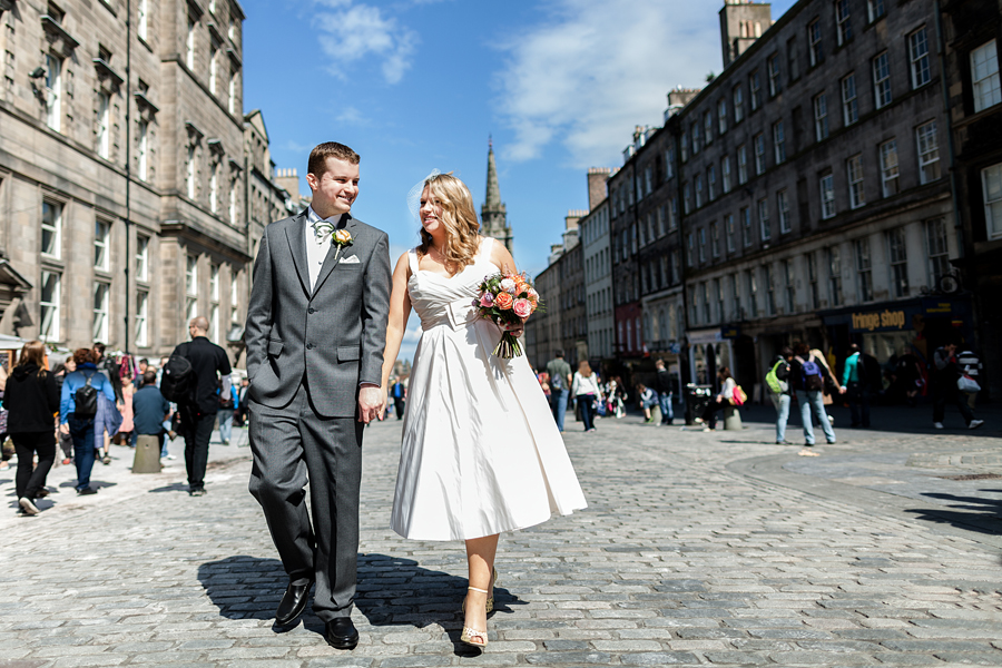 Happy bride and groom walking on Royal Mile