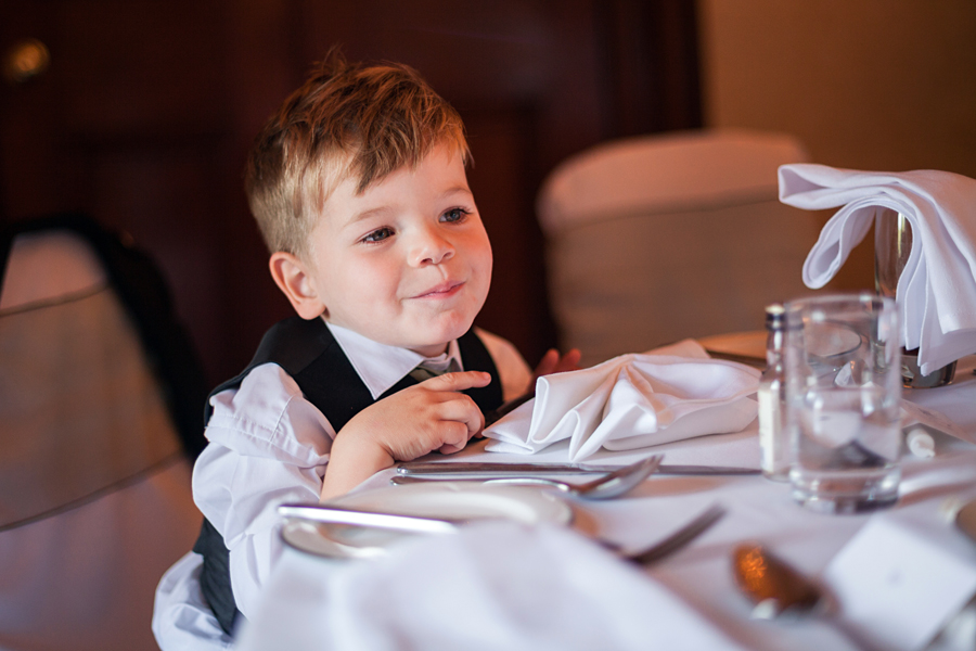 Sweet page boy watching wedding guests at Dalhousie Castle wedding reception
