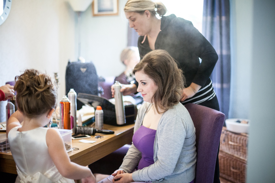 Bride getting her hair done during the wedding preparations