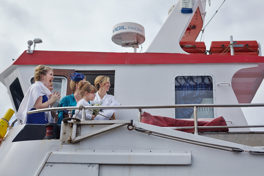 Happy bridesmaids seeing the bride getting on the boat in South Queensferry