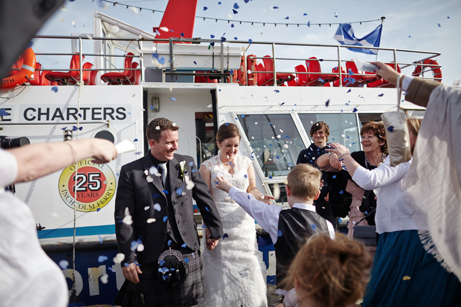 Bride and groom and their guests throwing confetti at Orocco Pier in Southqueensferry