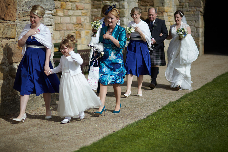Bride, her father and her bridesmaids marching to Inchcolm Abbey for the wedding ceremony