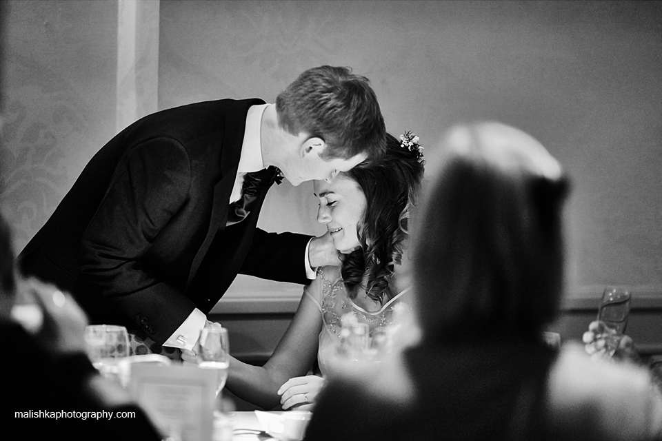 Tender moment between bride and groom during the speeches