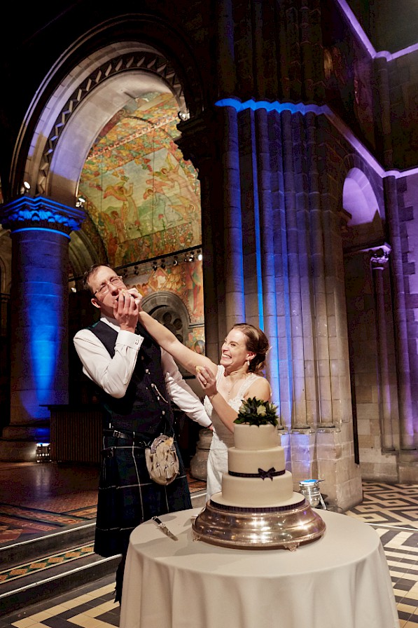 Bride and groom smashing the cake at city wedding Mansfield Traquair in Edinburgh